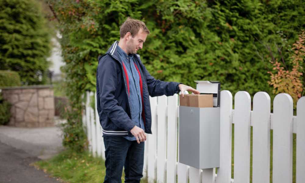 A man picks up a parcel from a mailbox