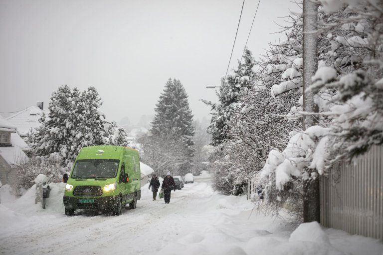 En Bring bil står på en snedækket gade