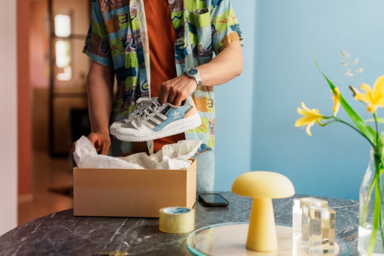 Mand pakker et par sneakers i en pakke