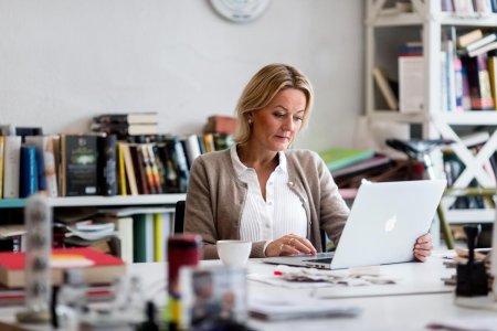 Kvinde ved skrivebord med computer