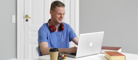 Mand med hovedtelefoner foran computeren
