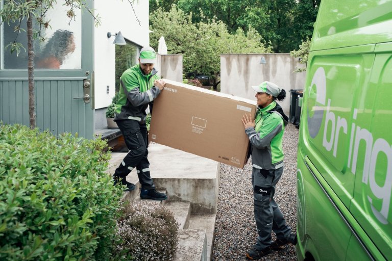 To Bring-chauffører medbringer en stor tung pakke til hjemmelevering