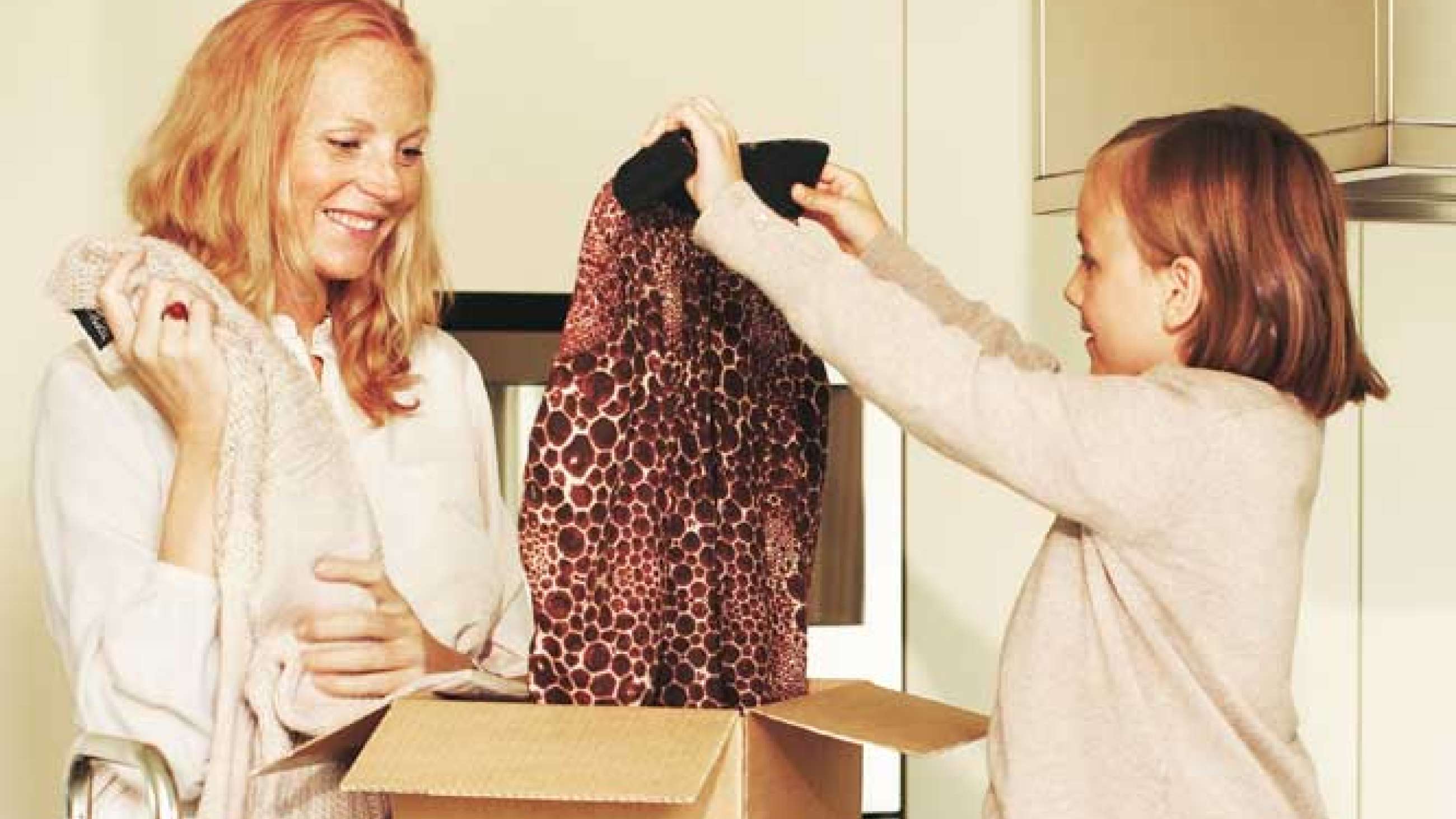 Kvinde og barn åbner en pakke tøj