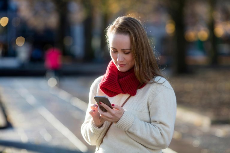 Ung kvinde handler med sin mobiltelefon